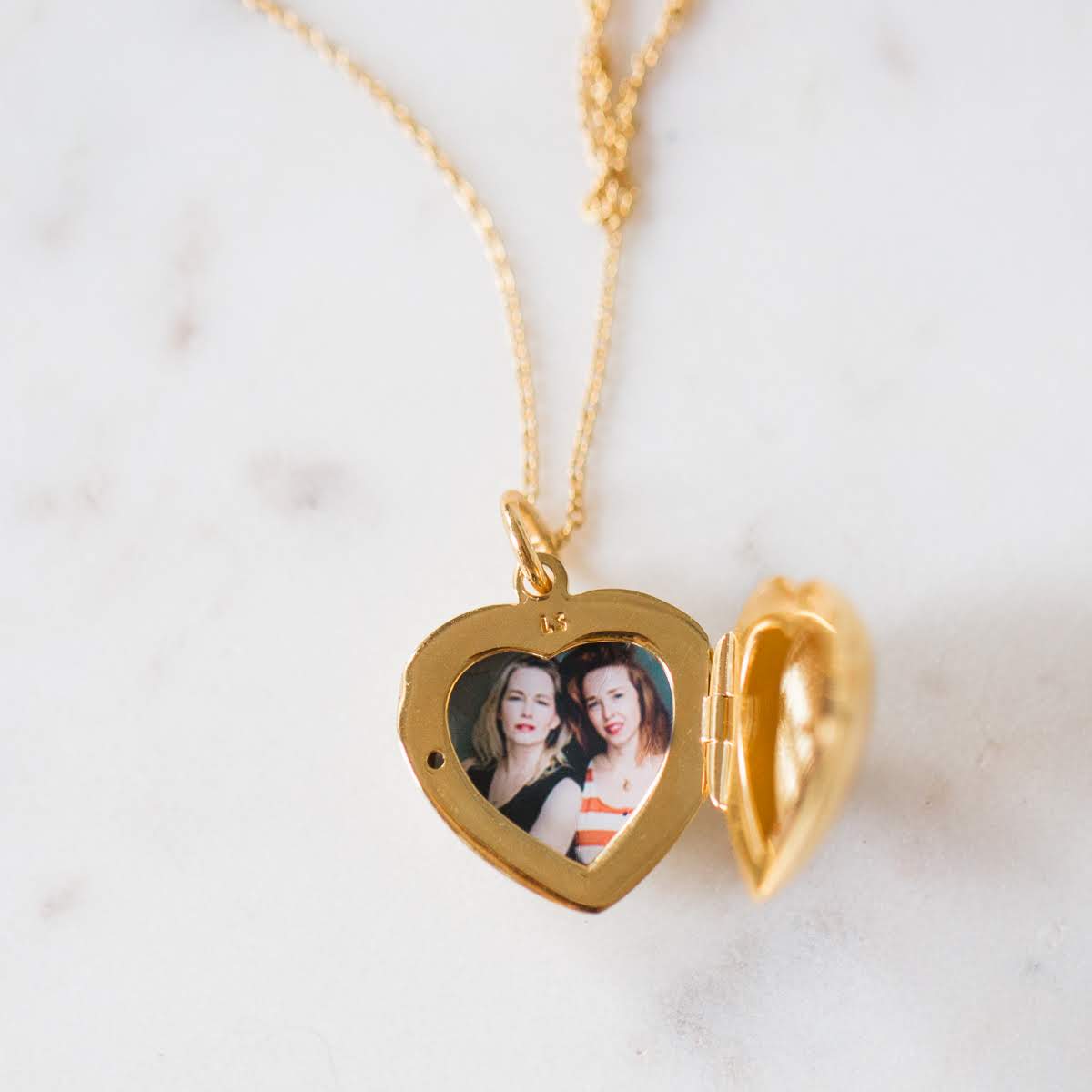 gold heart locket that holds one or two photos