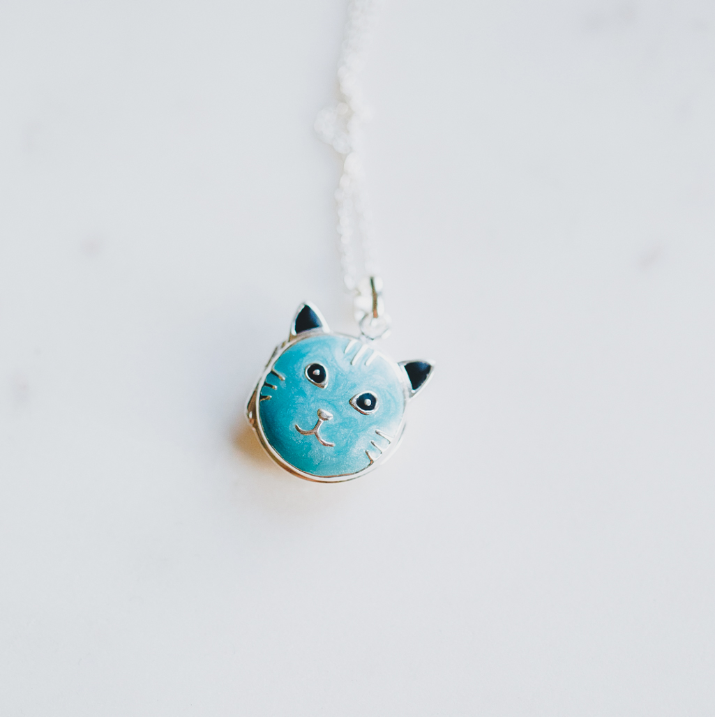 blue cat locket that holds a photograph