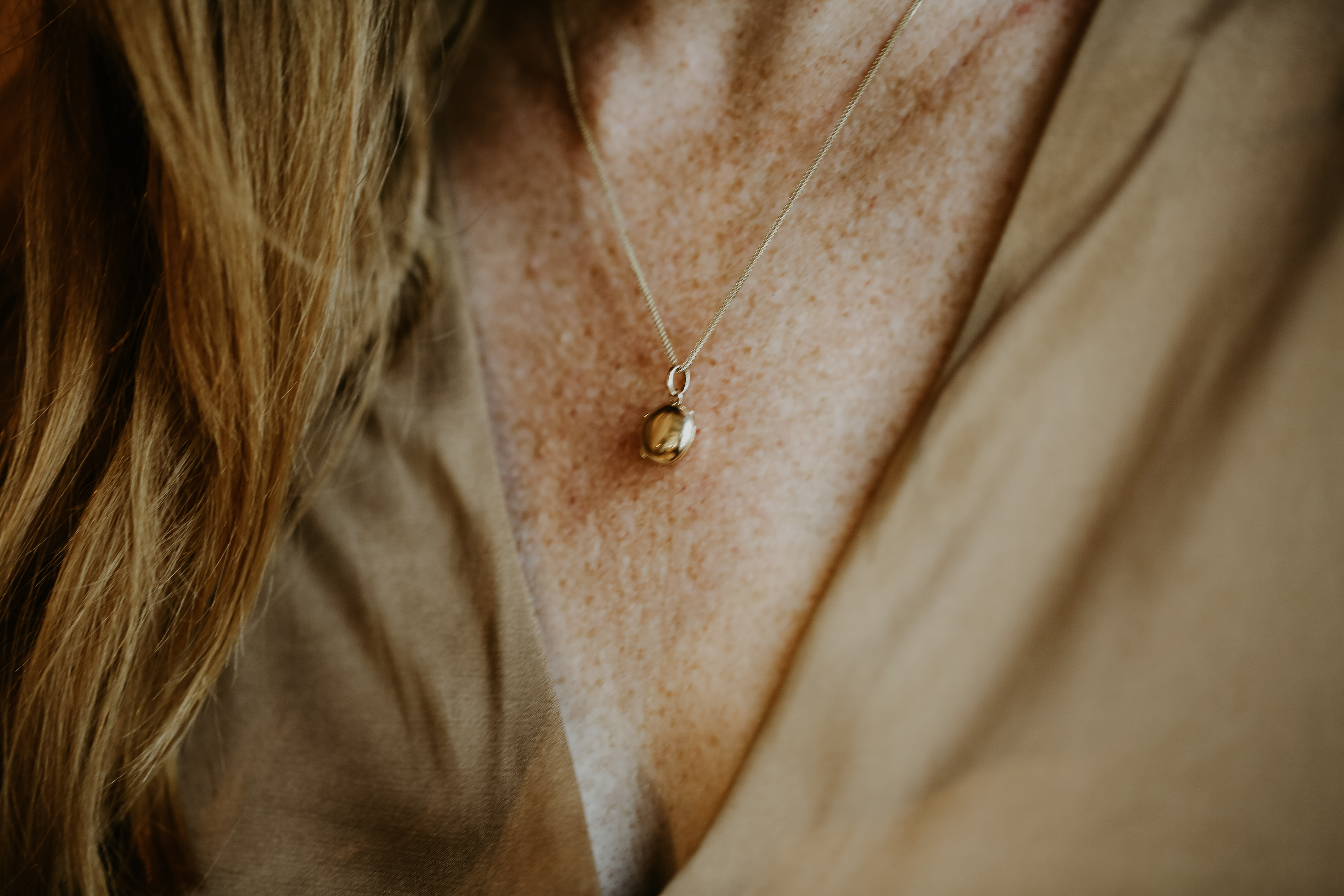 red haired woman wearing petite locket in solid gold