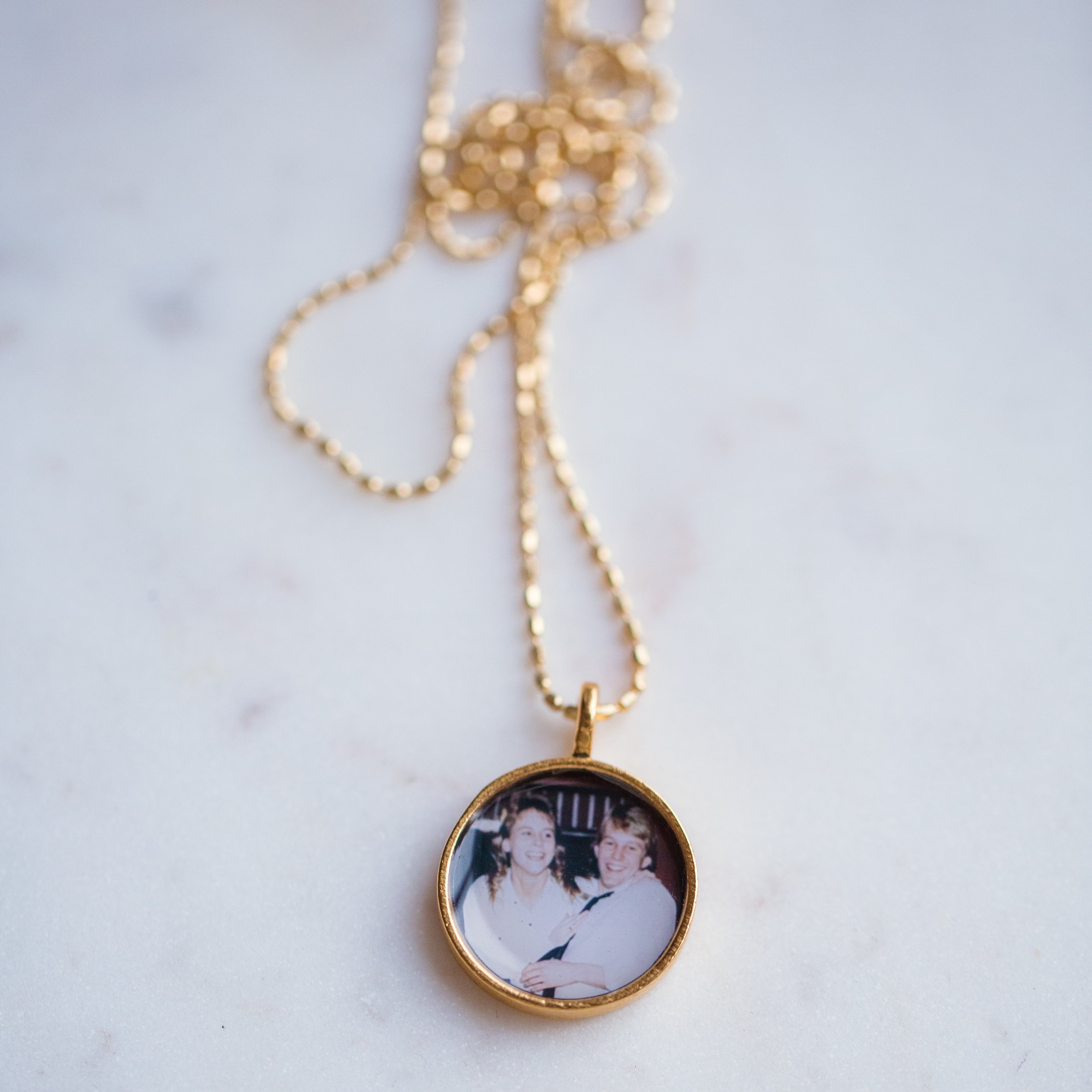 The Gold Penny Locket, a round pendant with a photo inside