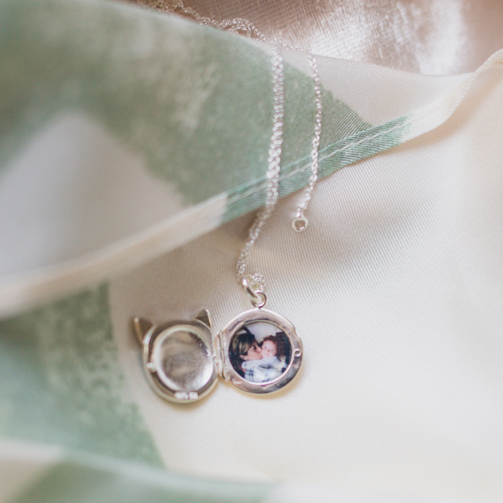 memorial locket gift for daughter with photograph of daughter alongside mom who passed away by suicide, locket is a blue cat face on front