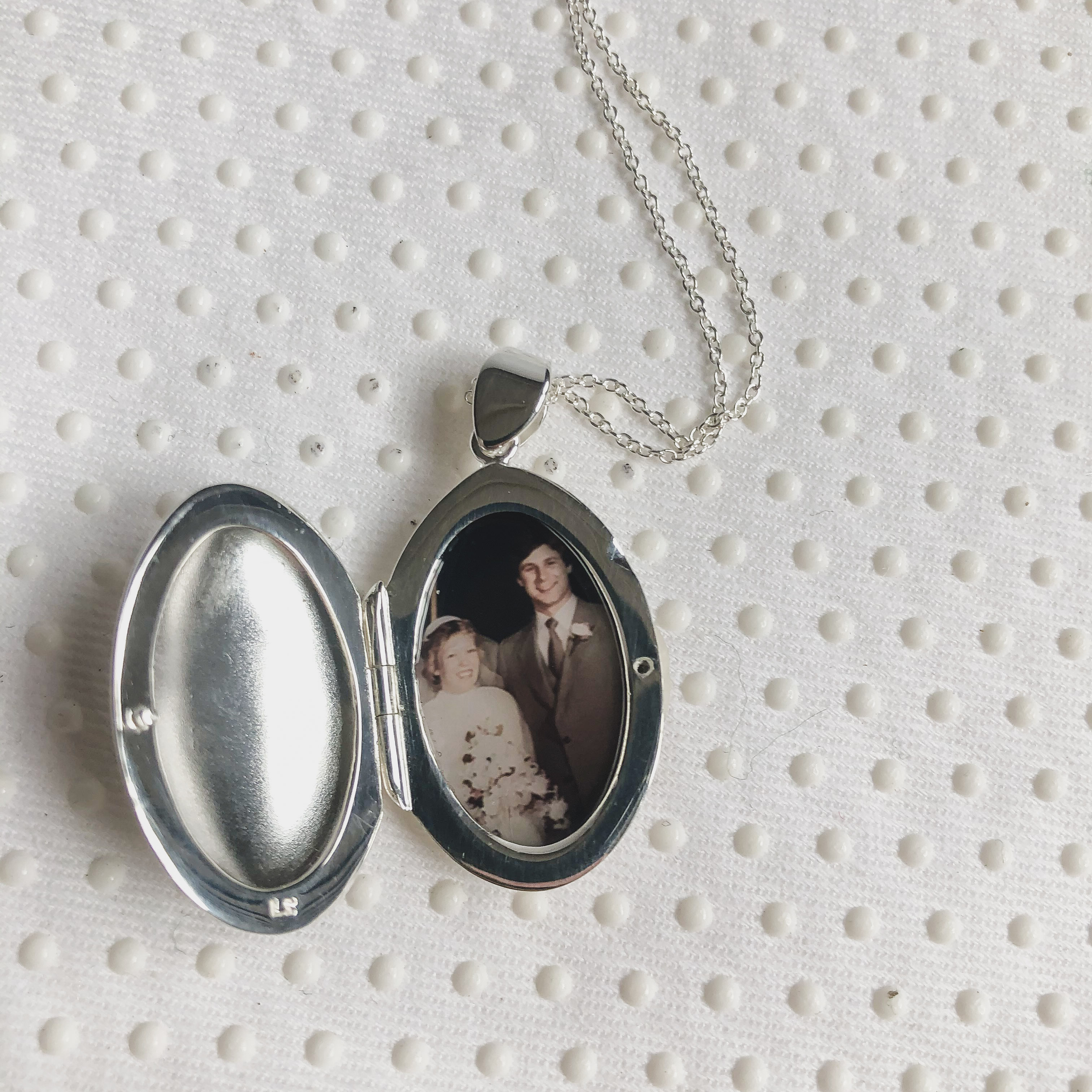 silver oval locket with photo of couple from 1970s on their wedding day