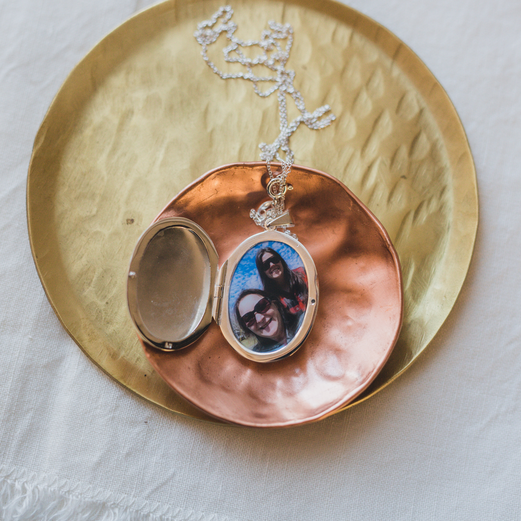 large silver oval pendant that holds a picture that they put in for you