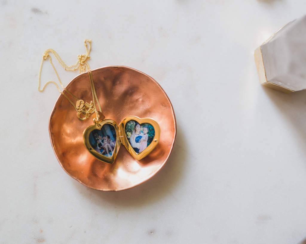 gold heart locket with two pictures inside of nanny with the kids she cared for for years