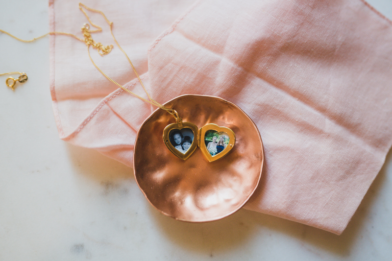 small gold heart locket with two photographs inside 