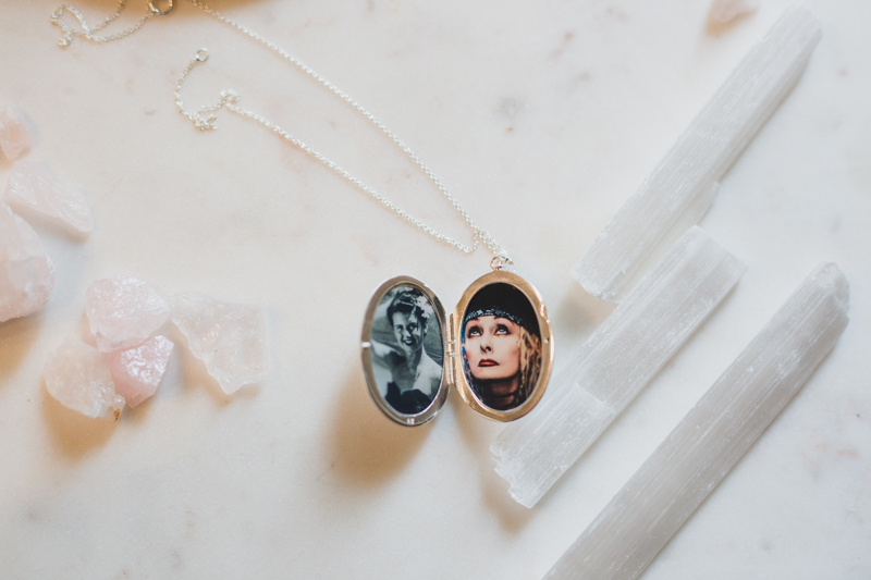 a silver etched oval locket on white marble with two photographs already placed inside of grandmothers