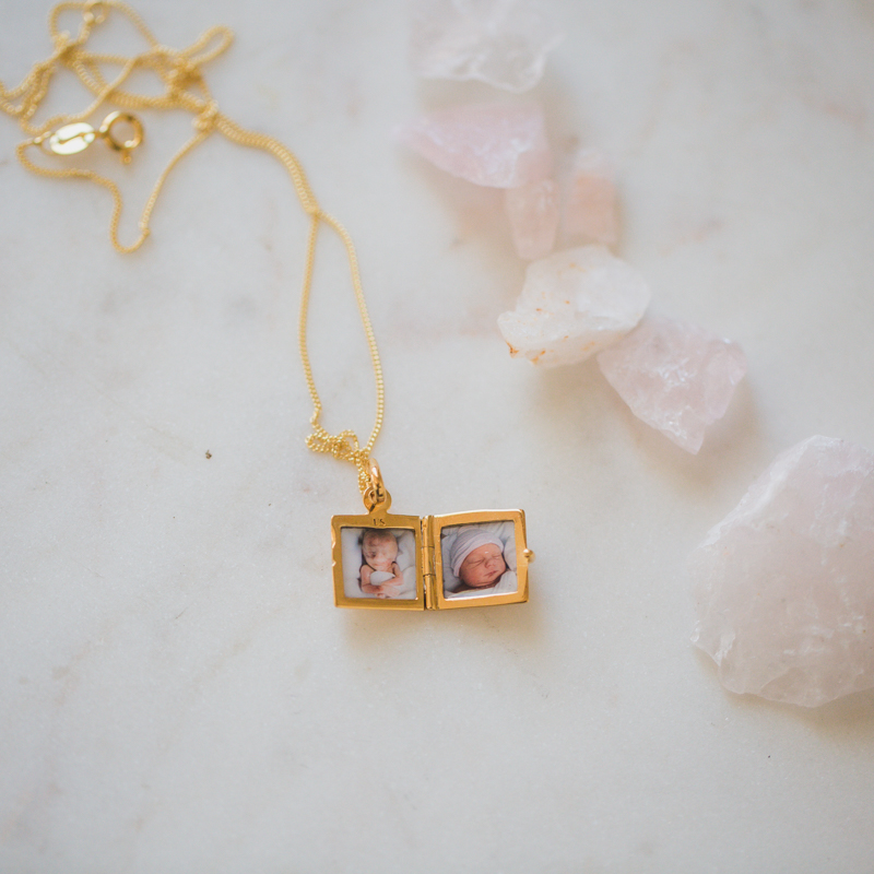 very small square gold locket holding two photos pictures inside