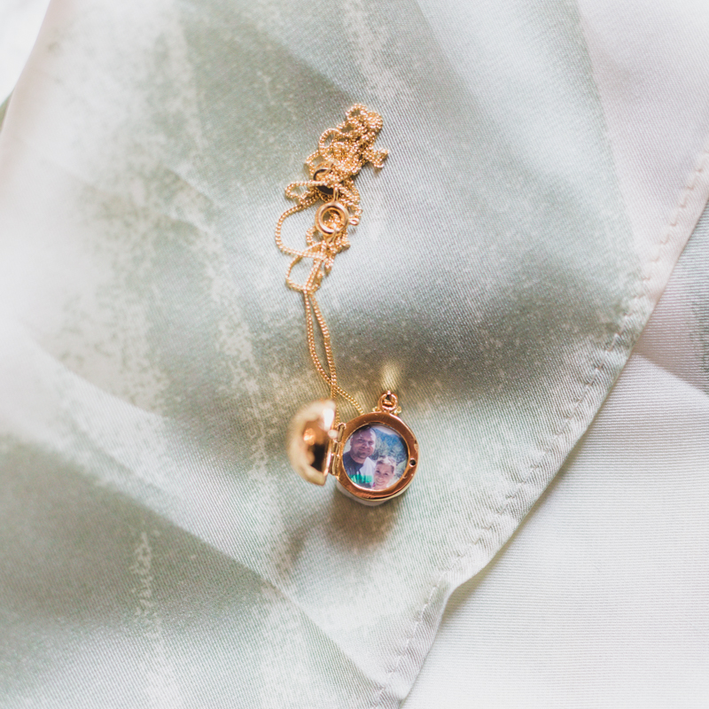 gold photo locket shaped like a disco ball with photograph of married couple hiking in redwood forest