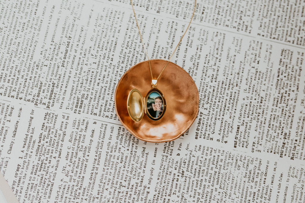 gold oval locket with picture of young lovers inside