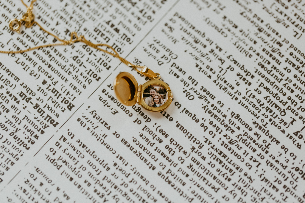 photo of couple smiling placed inside tiny gold round locket necklace