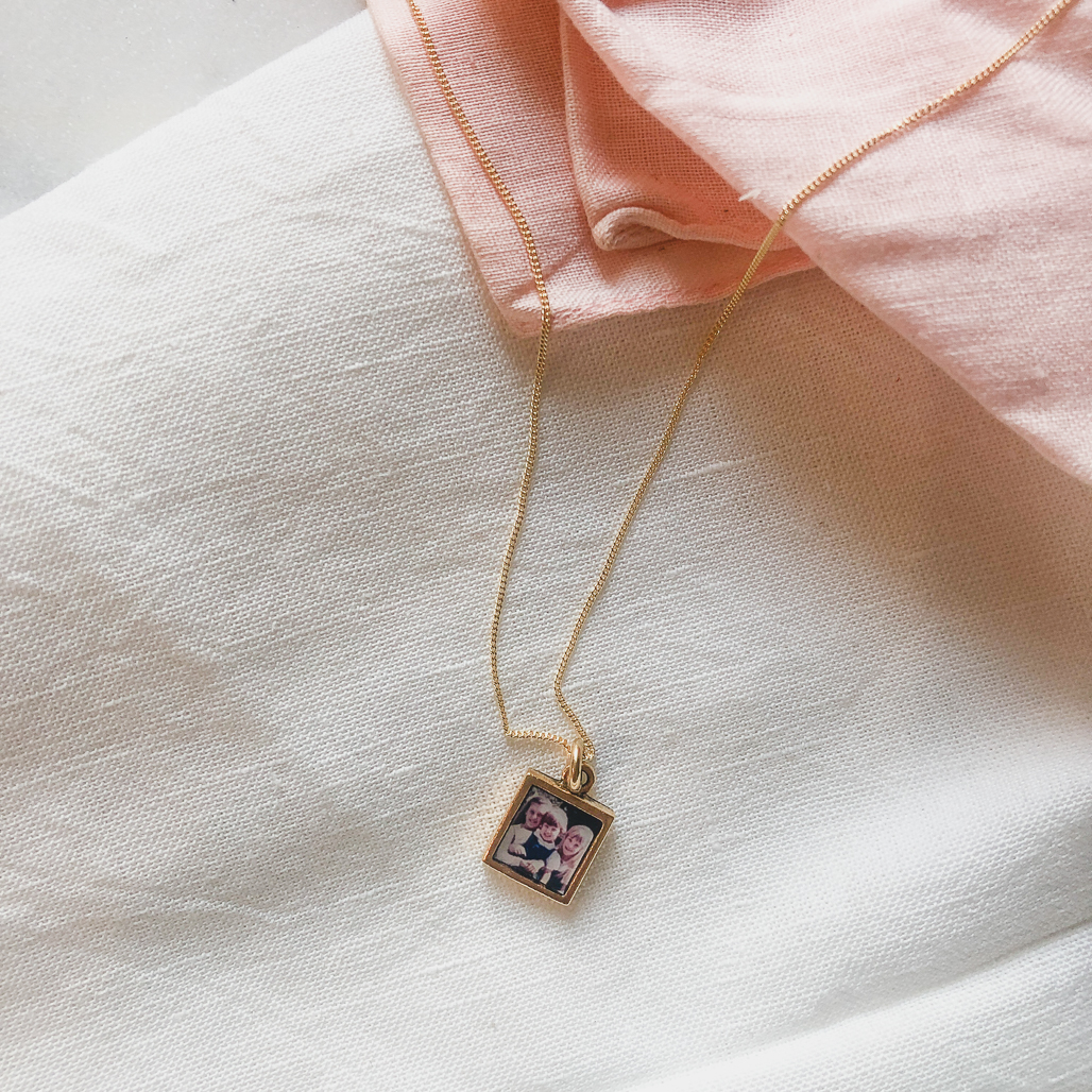 little square locket with photograph of sisters inside