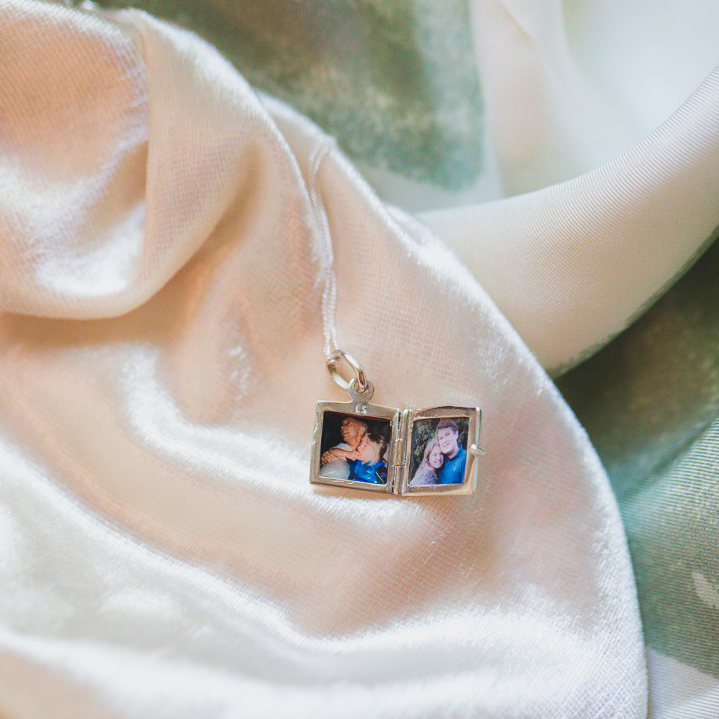 silver square locket with two photos inside, called The Dorothy Locket, very small and modern