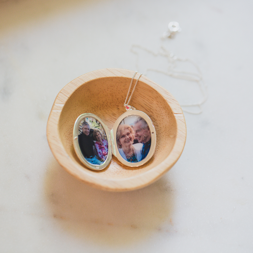 silver etched modern locket with double photos placed inside safely for grieving wife