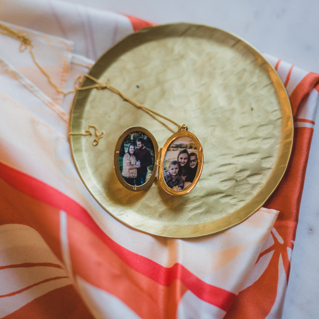 gold oval pendant locket necklace keepsake jewelry with photographs inside of a married couple one on side and their kids on the other