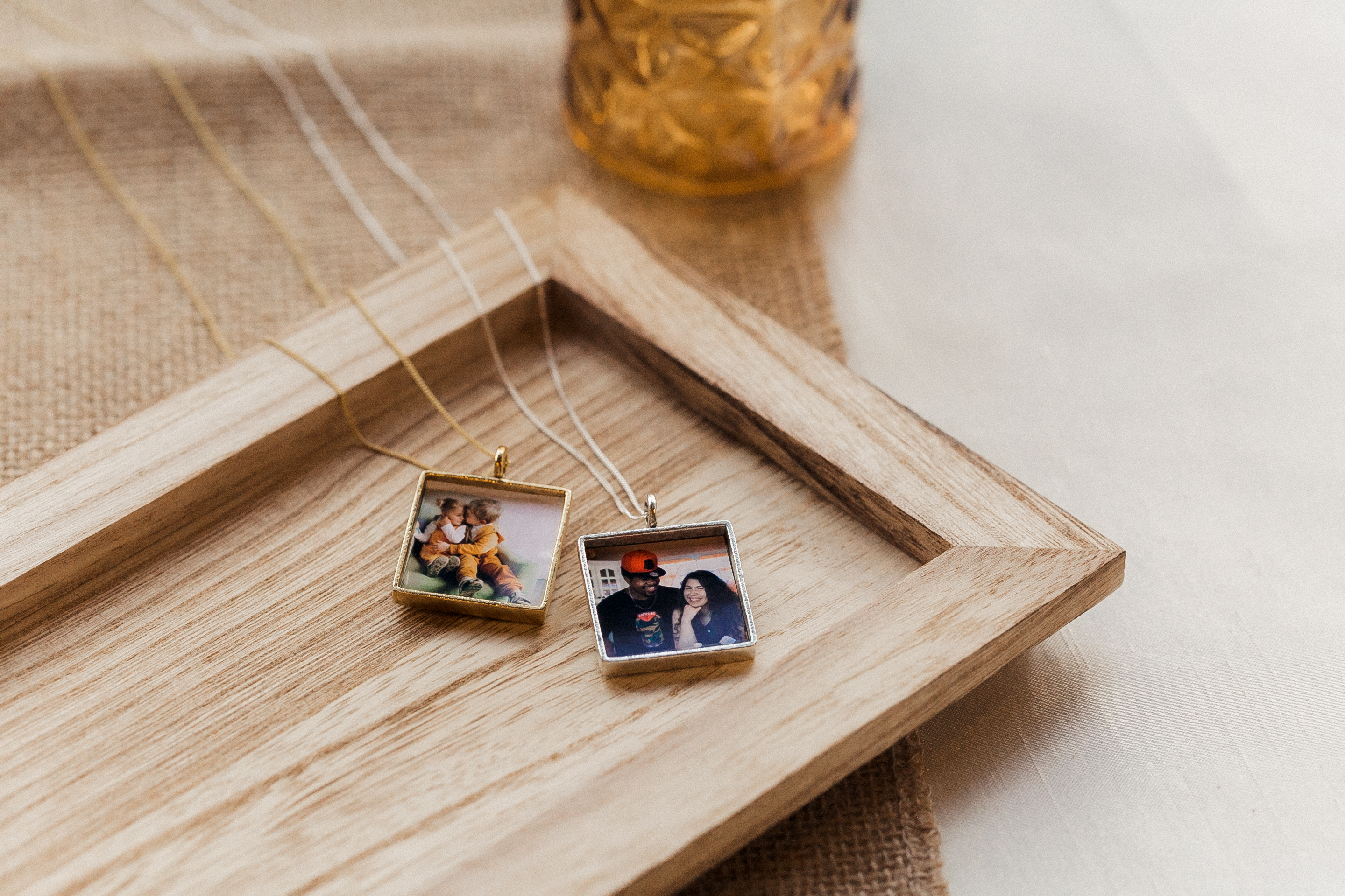 one inch square locket necklace in gold and silver with cropped photographs inside